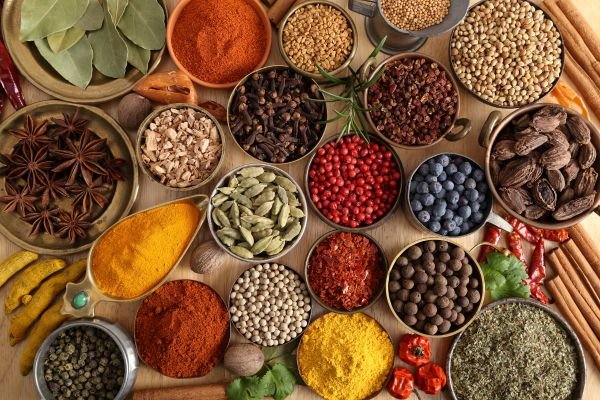 A variety of Indian whole and ground spices beautifully arranged in bowls – representing the Top 5 Indian Spices in Demand Globally.